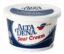 A container of sour cream sitting on top of a table.
