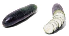 A cucumber and an eggplant are sitting next to each other.