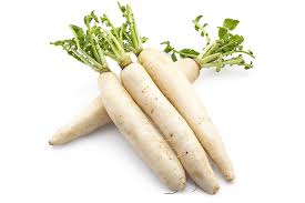 A group of white carrots with green stems.