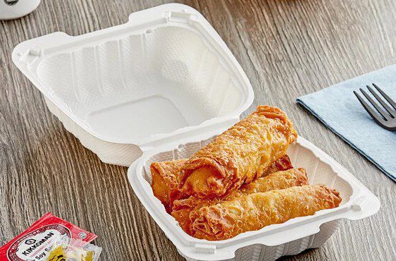 Three fried spring rolls in takeout container